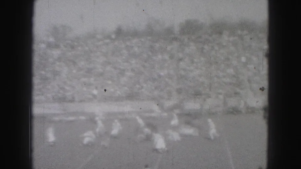Distant 1946 Harrisburg football action filmed from a spectator viewpoint, with the stands filled behind the field.