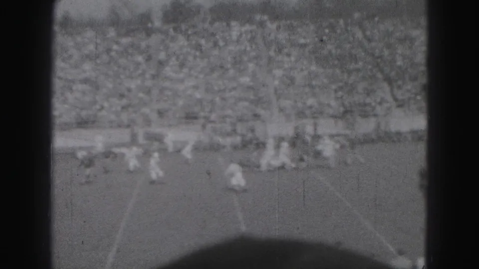 Players reset or move downfield during the 1946 Harrisburg football game, seen from a distant home-movie viewpoint over the field.