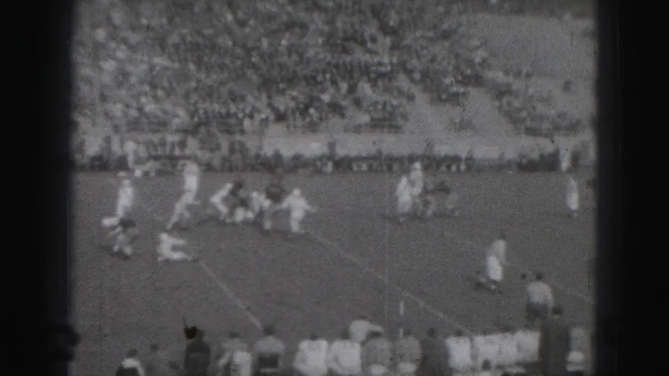Harrisburg, Pennsylvania 1946 home-movie frame showing football players on the field with spectators filling the stadium stands.
