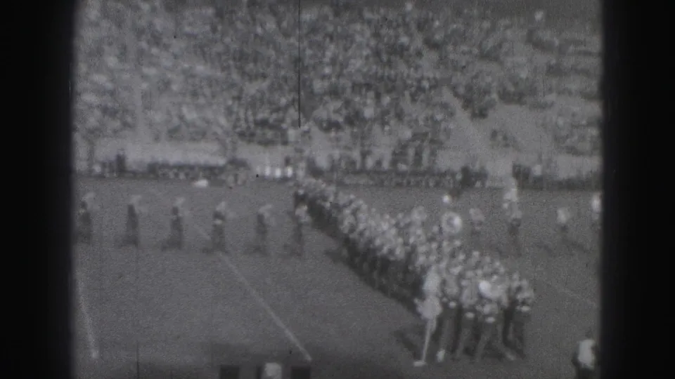 1946 Harrisburg football game view showing marching band lines on the field and spectators filling the stands.
