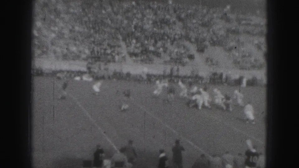 Wide 1946 Harrisburg football scene with players in motion, band lines, and a large seated crowd beyond the field.