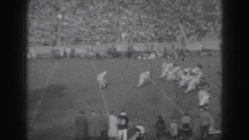 In the 1946 Harrisburg match footage, players bunch near a marked line as sideline viewers watch from close range.