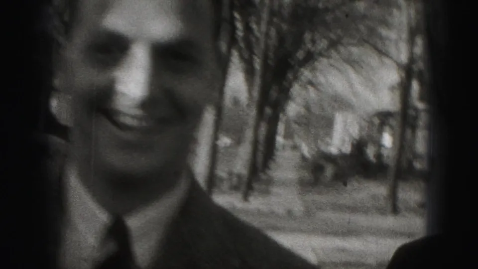 A smiling adult man in a suit is framed close to the camera in 1946 Harrisburg home-movie footage.