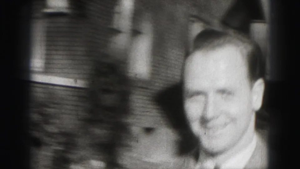 The man fills the frame in a soft, blurred close view as he reaches the camera in the 1946 home-movie clip.