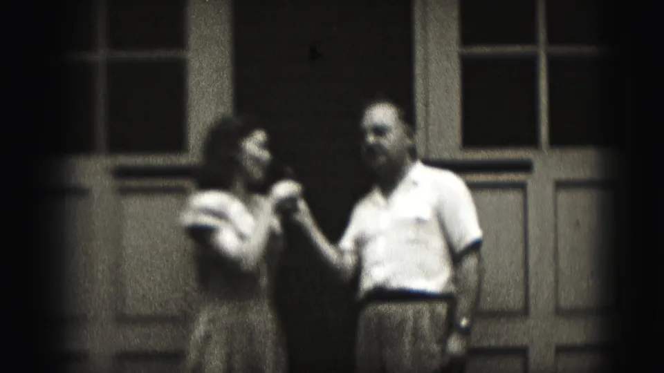 The woman reaches toward the man while both appear amused in a soft-focus 1946 New Cumberland home-movie frame.