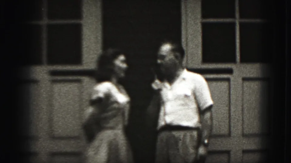 The couple turns toward one another with the microphone between them outside a New Cumberland building in 1946 footage.