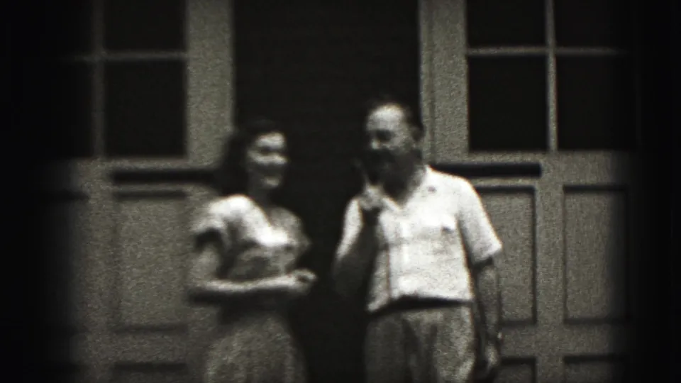 The woman and man stand side by side with the microphone visible, framed by doors and windows in New Cumberland, Pennsylvania footage.