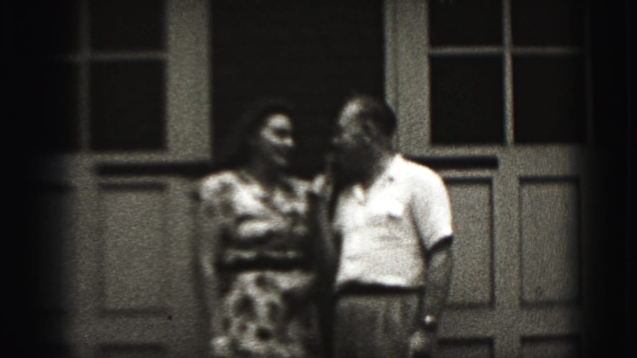 The adult couple turns toward one another outside the building in the 1946 New Cumberland 8mm scene.