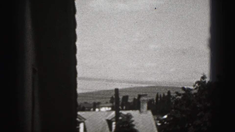 Window-framed view over rooftops, trees, and distant hills in New Cumberland, Pennsylvania.