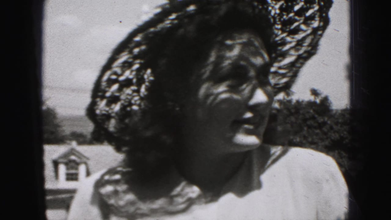 Young woman in a wide lace hat looks to the side outdoors.