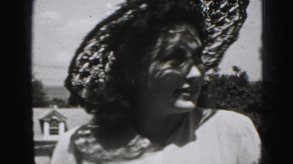 Young woman in a wide lace hat and light dress turns her face in sunlit 1946 New Cumberland home-movie footage.
