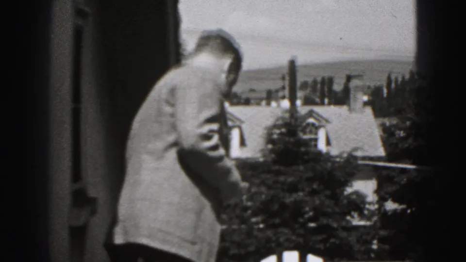 Adult man in a suit stands partly turned away on a porch or balcony in New Cumberland, Pennsylvania, in 1946.