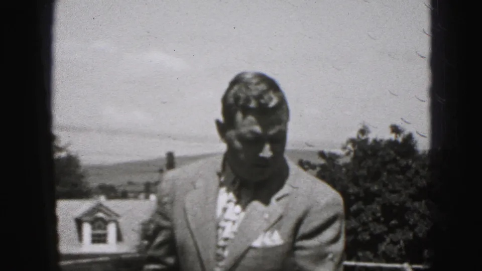 A suited middle-aged man looks down as if adjusting his jacket in 1946 home-movie footage from New Cumberland, Pennsylvania.