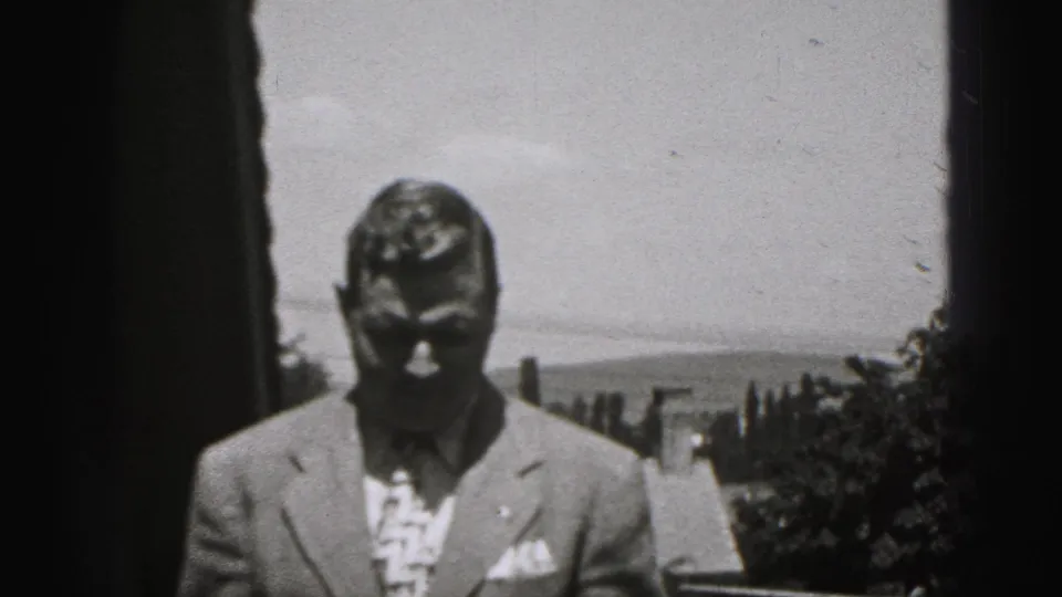 Adult man in a 1940s suit and tie stands outdoors in New Cumberland, Pennsylvania, looking down in bright sunlight.