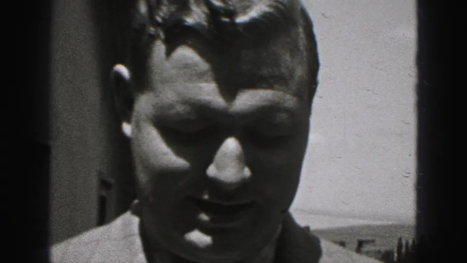 Close 1946 home-movie frame of a man facing the camera outdoors in New Cumberland, Pennsylvania, with strong sunlight and shadow.