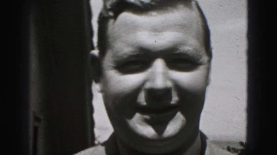 Smiling adult man faces the camera in a black-and-white 8mm frame from the 1946 New Cumberland home movie.