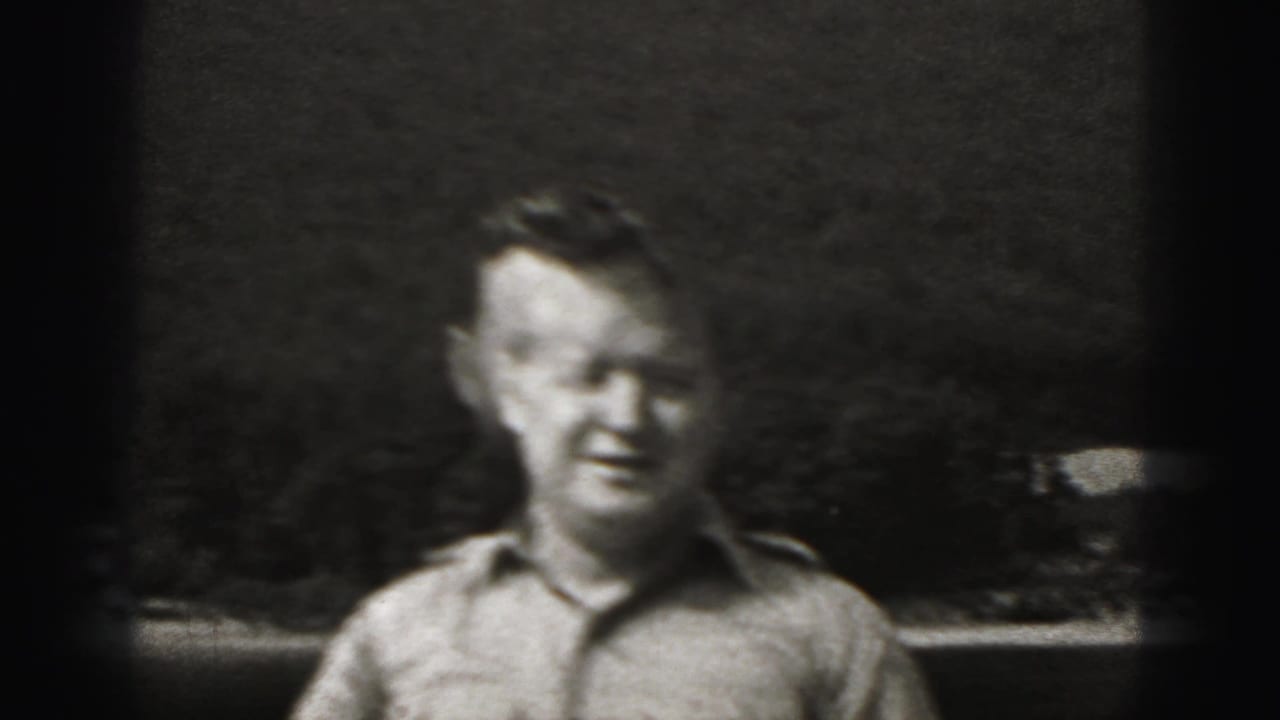 Man in a light button-up shirt standing outdoors in black-and-white film.
