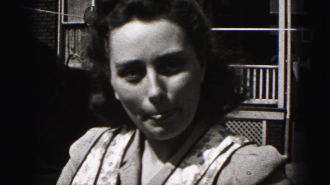 Young woman with dark styled hair looks down in a 1946 New Cumberland, Pennsylvania 8mm home-movie close-up.