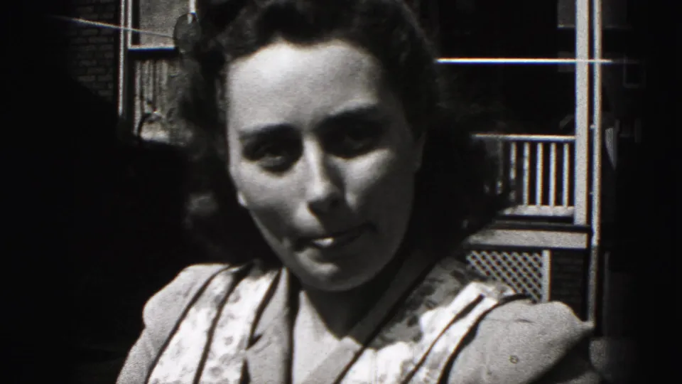 Young woman with dark styled hair looks down in a 1946 New Cumberland, Pennsylvania 8mm home-movie close-up.