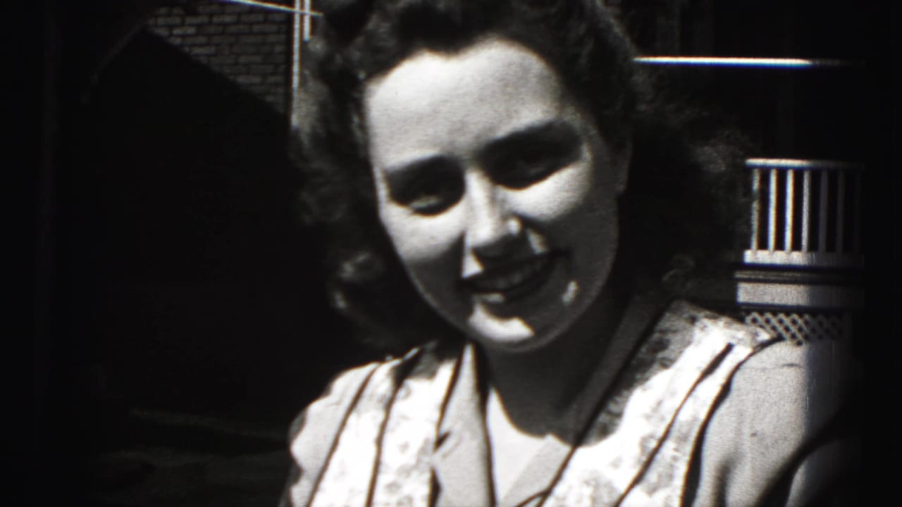 The woman smiles broadly toward the camera in a black-and-white 8mm frame from New Cumberland, Pennsylvania.