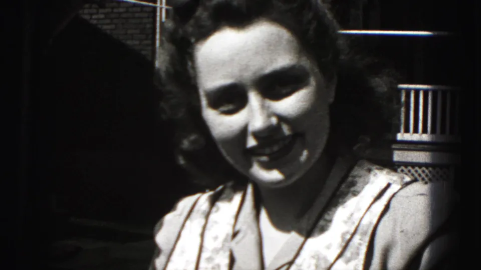 The woman smiles broadly toward the camera in a black-and-white 8mm frame from New Cumberland, Pennsylvania.