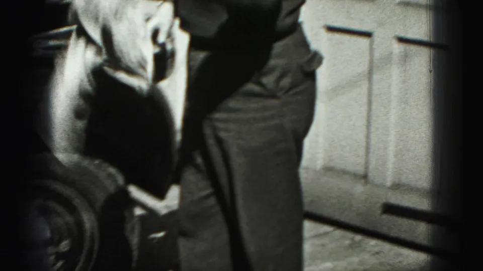 The final frame shows the man near the front fender and wheel, continuing to clean the car beside the garage door.