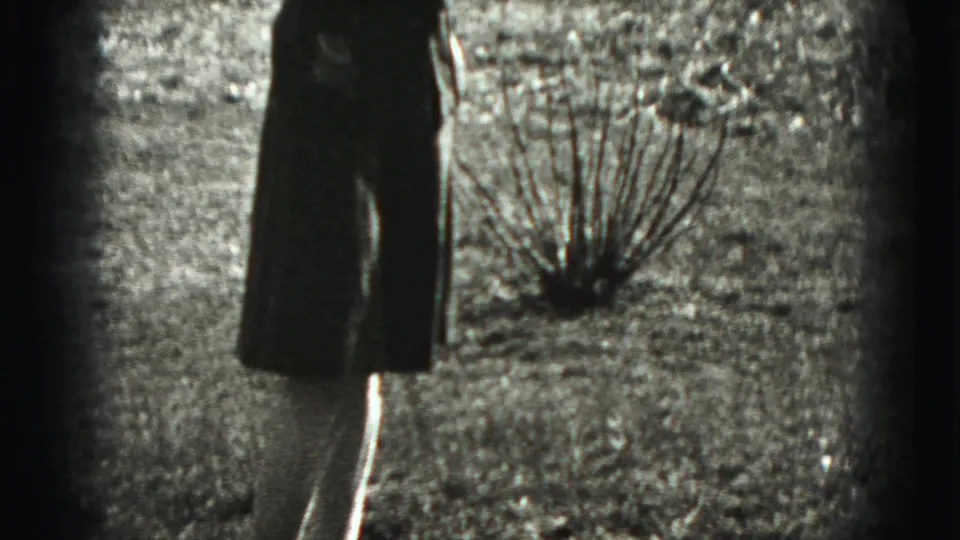 Profile view of the woman in a 1946 New Cumberland residential yard, with shrubs, fencing, and houses visible.