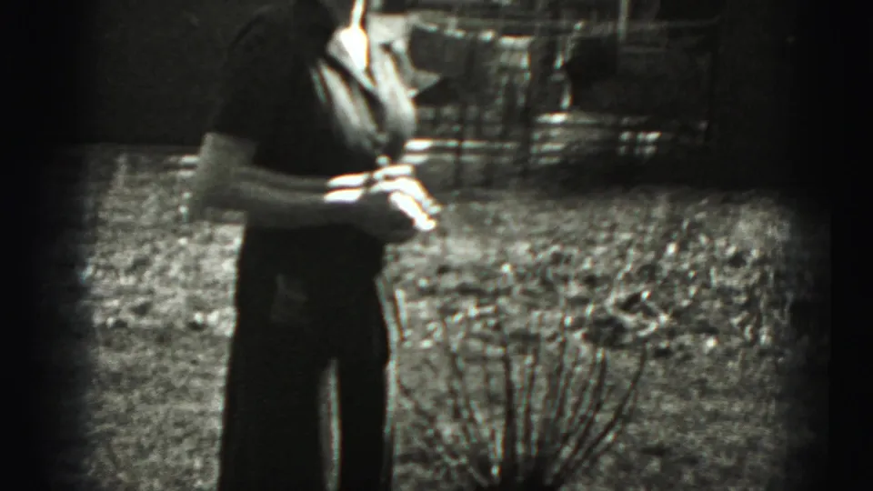 A woman stands in an outdoor grassy area in 1946 New Cumberland home-movie footage, partly cropped and softly focused.