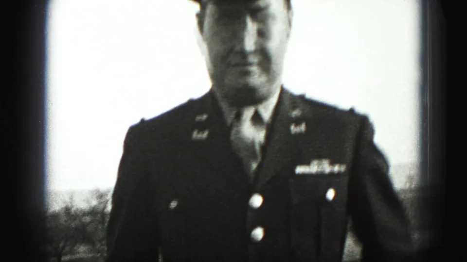 In 1946 New Cumberland home-movie footage, a uniformed adult man stands outdoors near the camera with cap, tie, and jacket insignia visible.