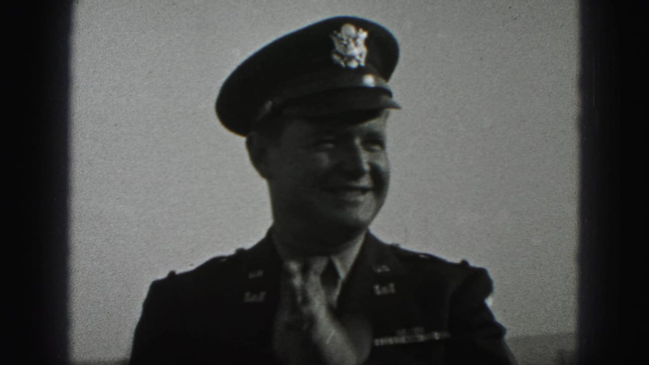 Smiling uniformed officer adjusts his tie while facing the camera.