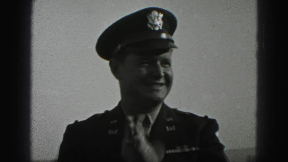 In 1946 New Cumberland home-movie footage, a smiling uniformed officer in a peaked cap adjusts his tie outdoors.
