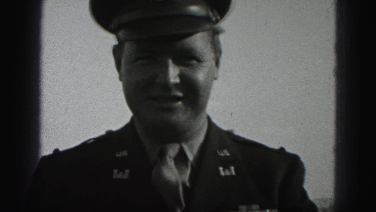 Uniformed officer in peaked cap smiles toward the camera.