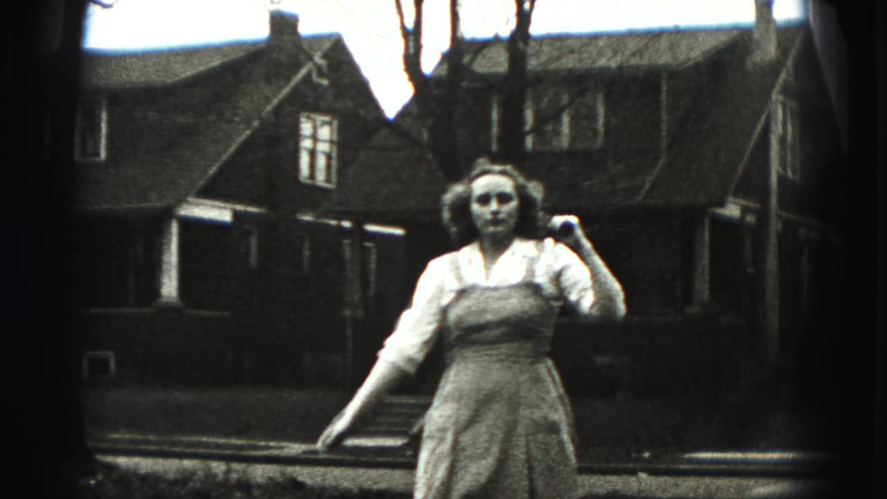A closer 1946 New Cumberland frame shows the young woman holding the stick at shoulder height in front of a residential house.
