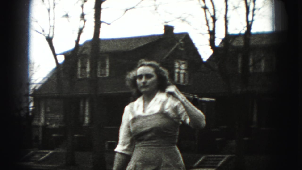 The young woman in the New Cumberland 1946 footage faces slightly aside while holding a long stick or golf club near her shoulder.