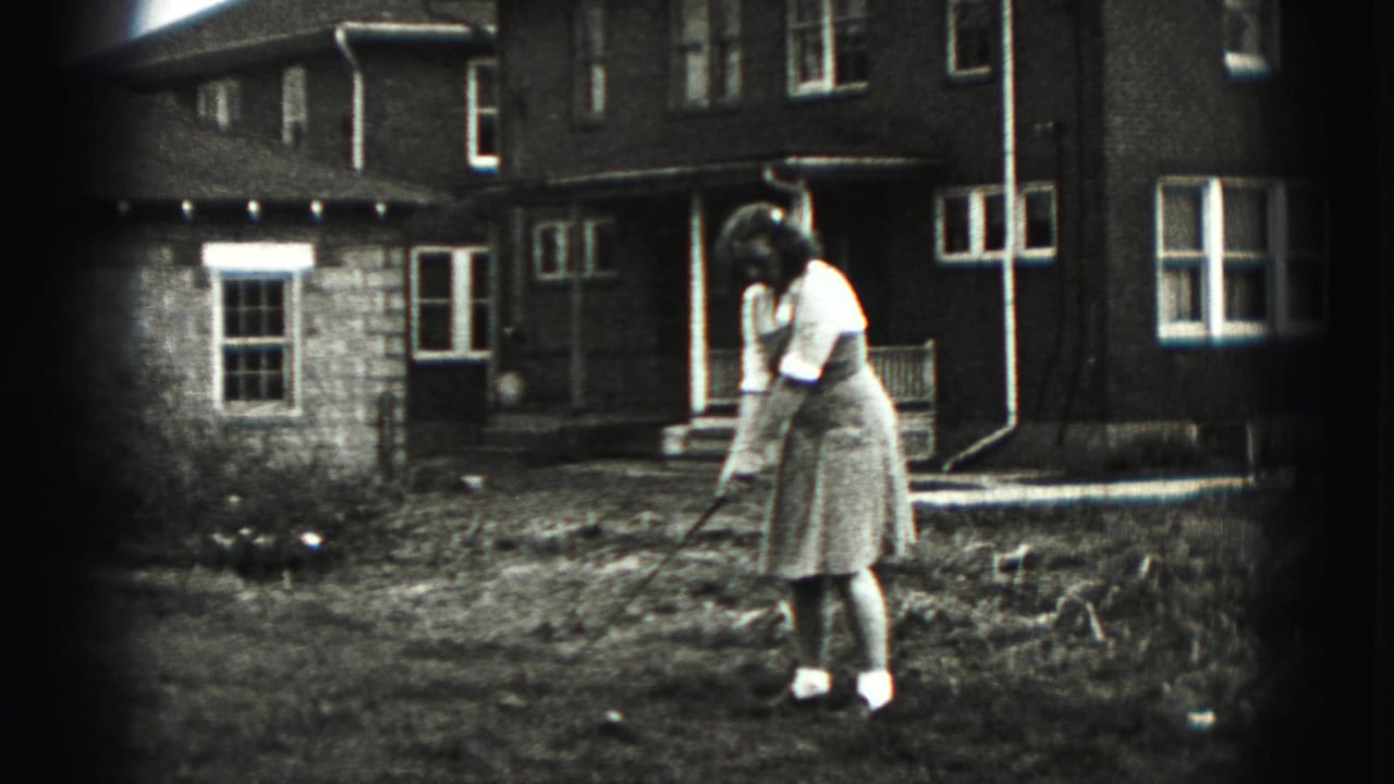 In New Cumberland, Pennsylvania, a woman in 1940s dress addresses a golf ball in a residential backyard.