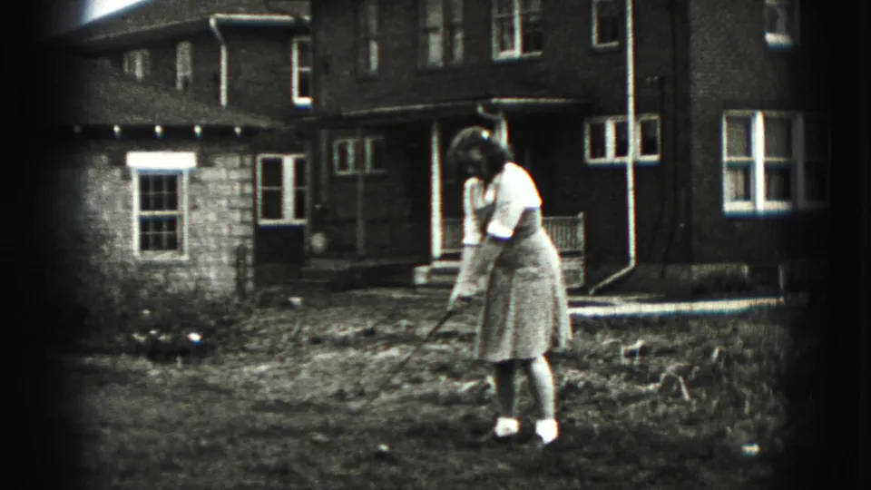 In New Cumberland, Pennsylvania, a woman in 1940s dress addresses a golf ball in a residential backyard.