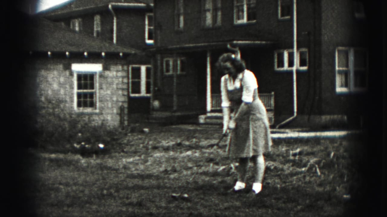 A woman resets her golf club on a modest New Cumberland lawn, with a residential exterior behind her.