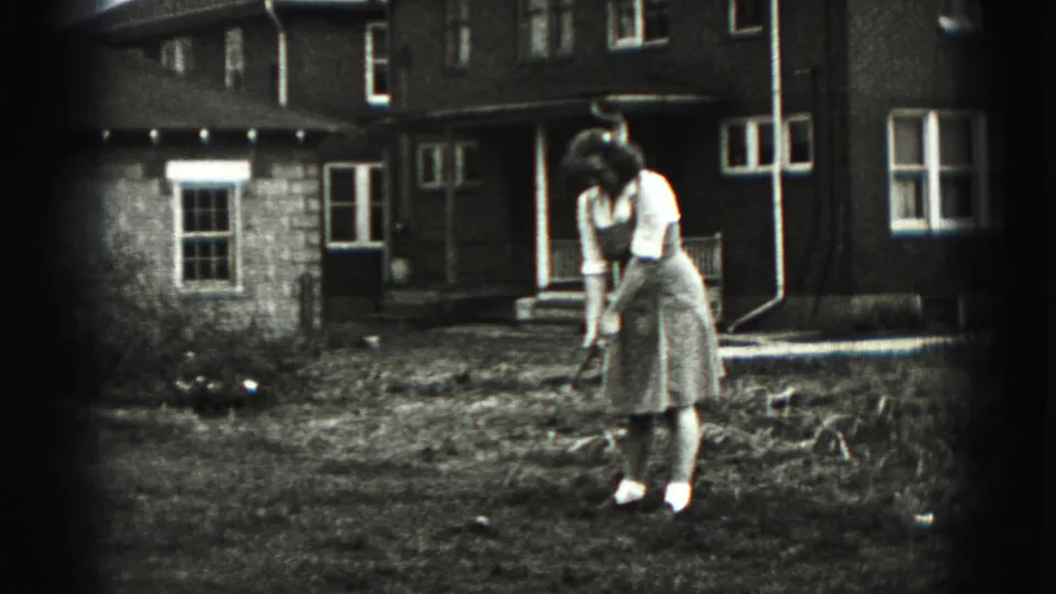 In 1946 New Cumberland home-movie footage, a woman prepares a golf swing in a backyard beside a brick house and porch.