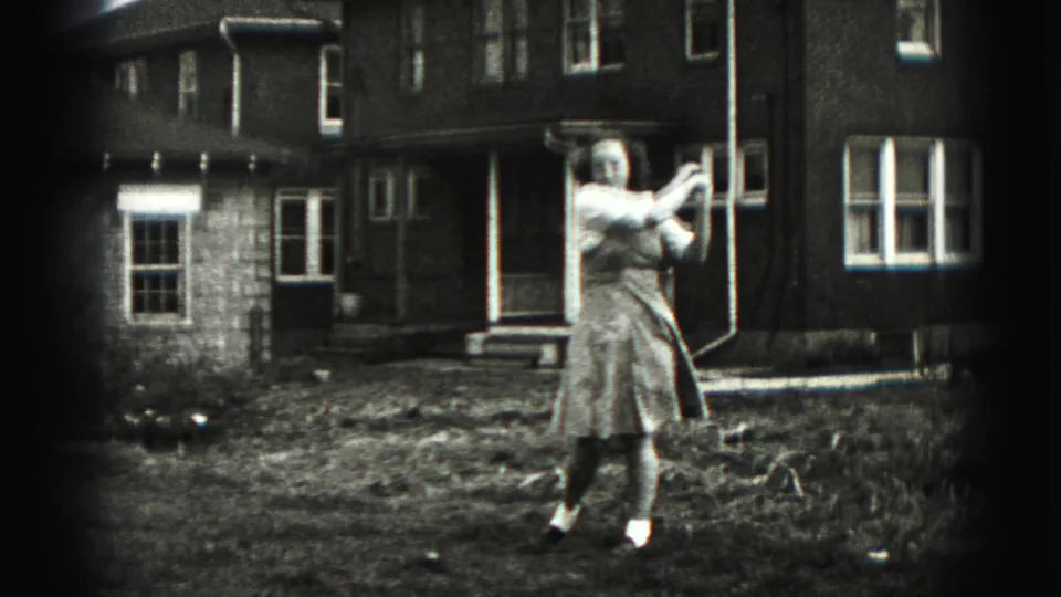 In New Cumberland, Pennsylvania, a woman in a 1940s-style dress prepares a golf swing in a backyard with a brick house behind her.
