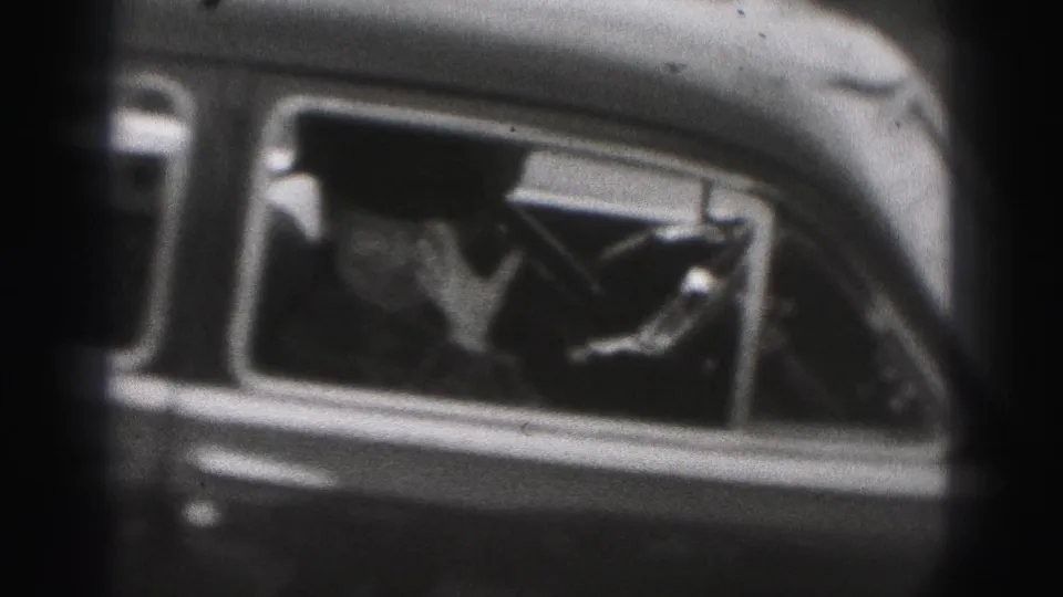 In the 1946 New Cumberland home movie, a passenger is seen through a rounded car window with a raised hand.