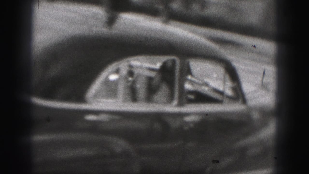 A rounded mid-century car passes in the New Cumberland 1946 footage as a passenger waves through the side window.