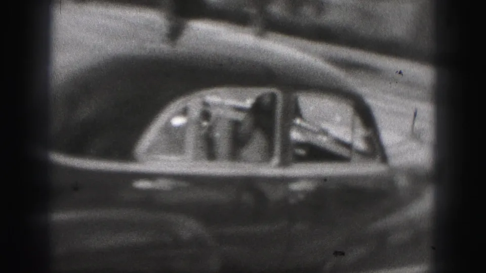 A rounded mid-century car passes in the New Cumberland 1946 footage as a passenger waves through the side window.