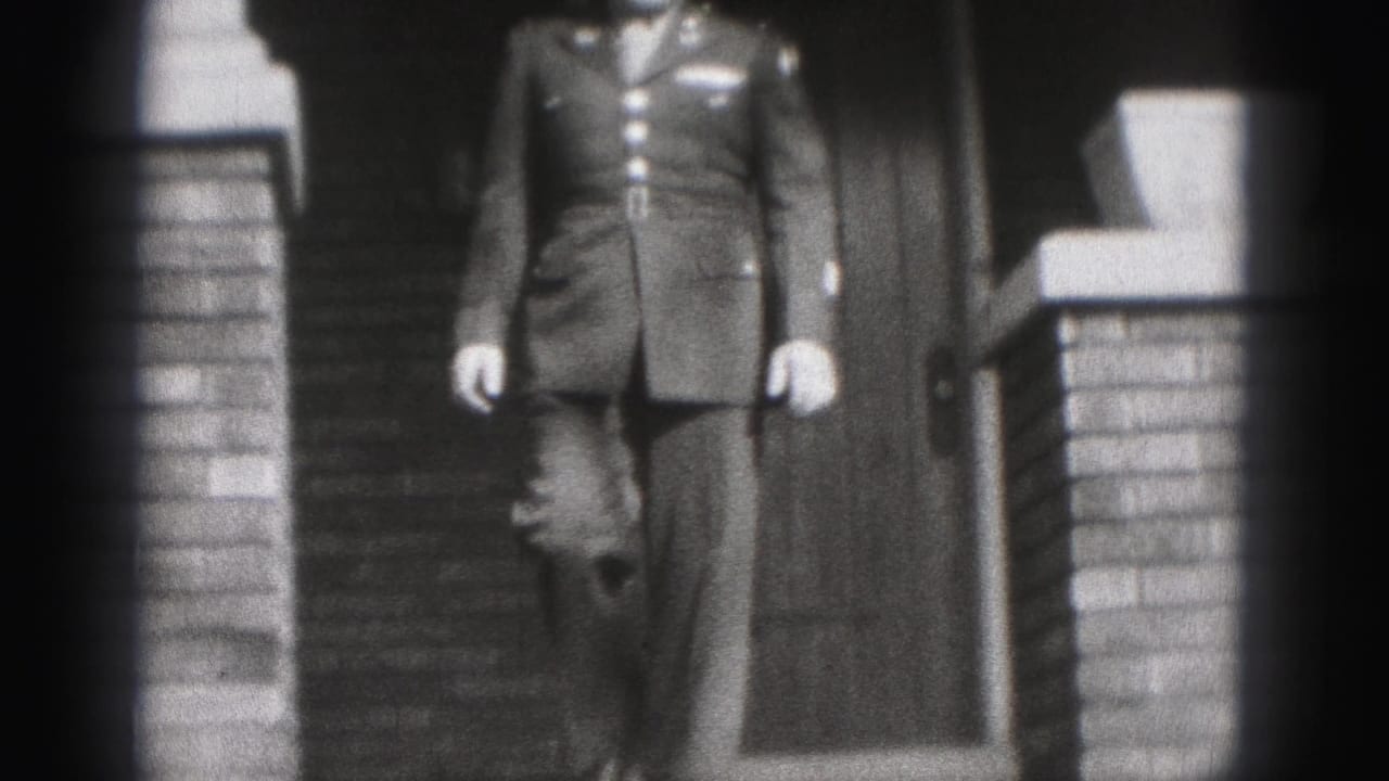 Uniformed man stepping down front porch steps beside brick columns.