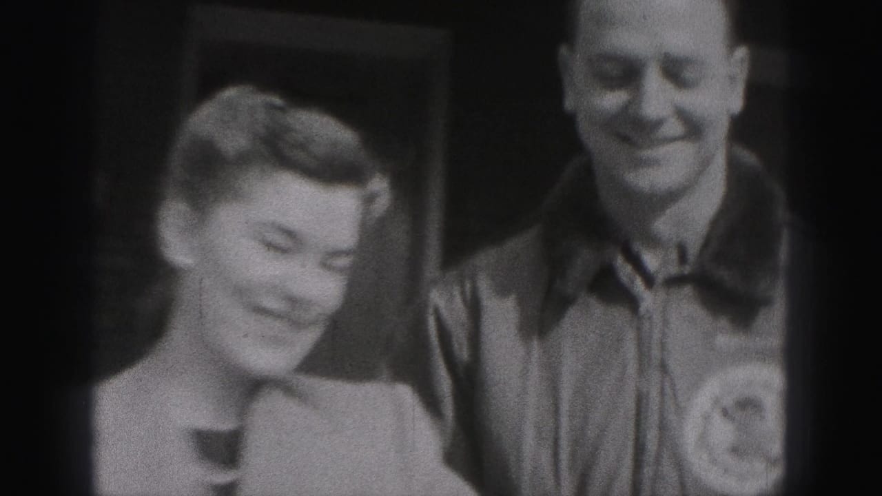 Young woman and young man smiling near a doorway.