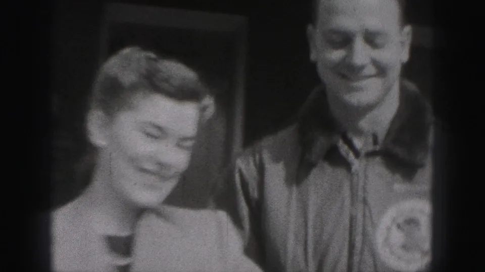 In 1946 New Cumberland footage, a young woman and young man stand close together and smile toward the camera near a doorway.