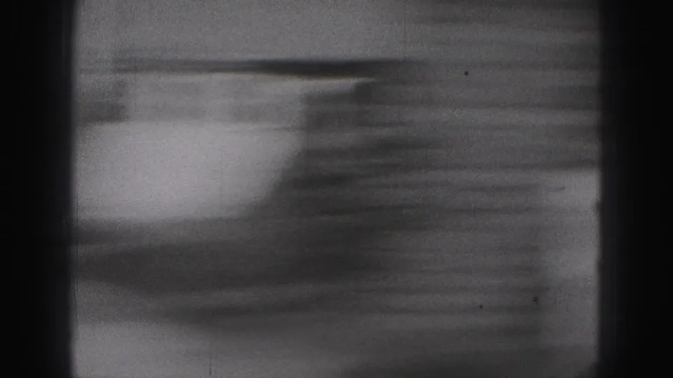 Handheld 8mm motion blur sweeps across what appears to be a brick exterior during the brief 1946 home-movie shot.