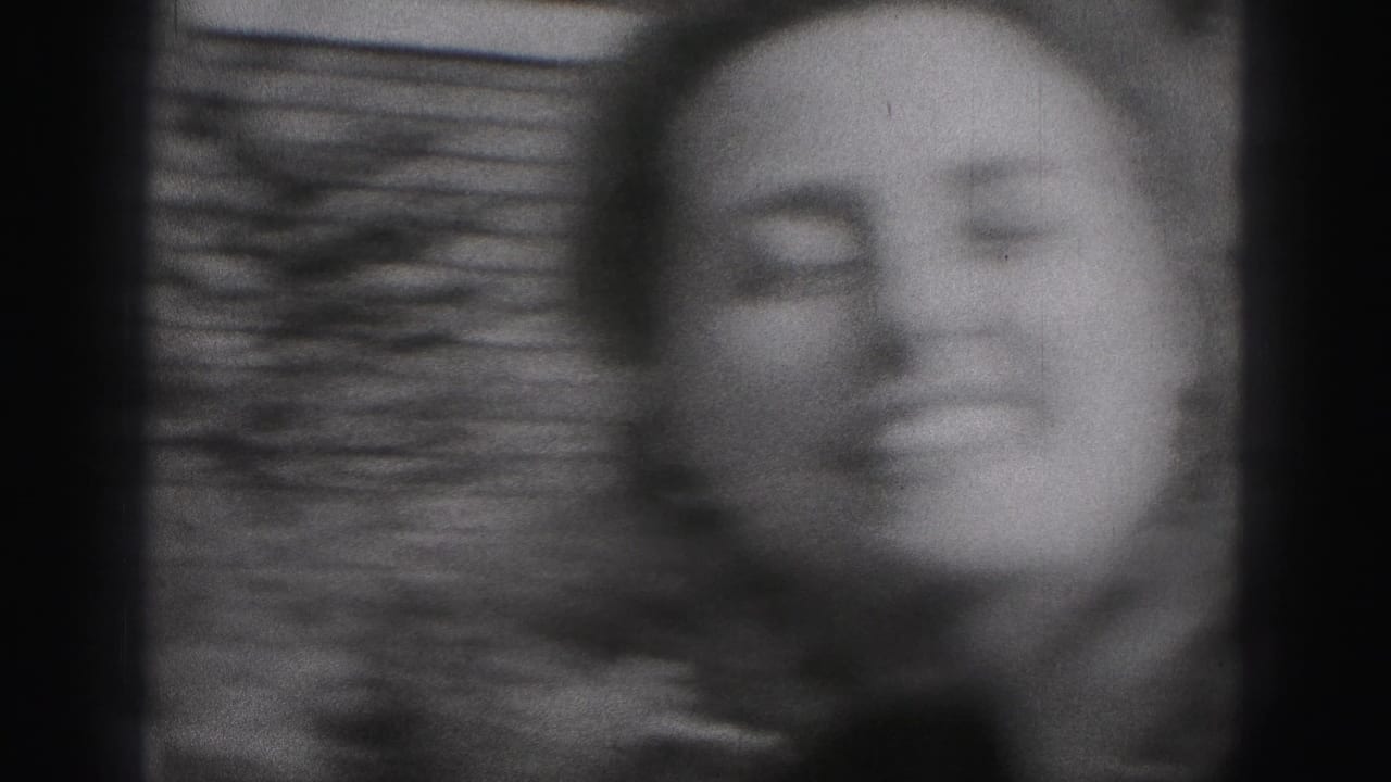 Soft black-and-white 1946 home-movie frame of a smiling woman outdoors in New Cumberland, Pennsylvania.