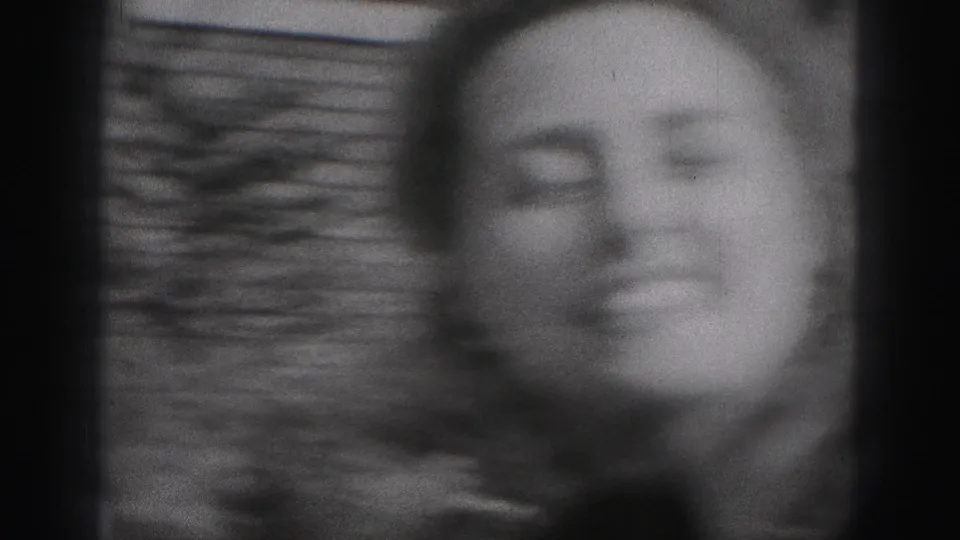 Soft black-and-white 1946 home-movie frame of a smiling woman outdoors in New Cumberland, Pennsylvania.