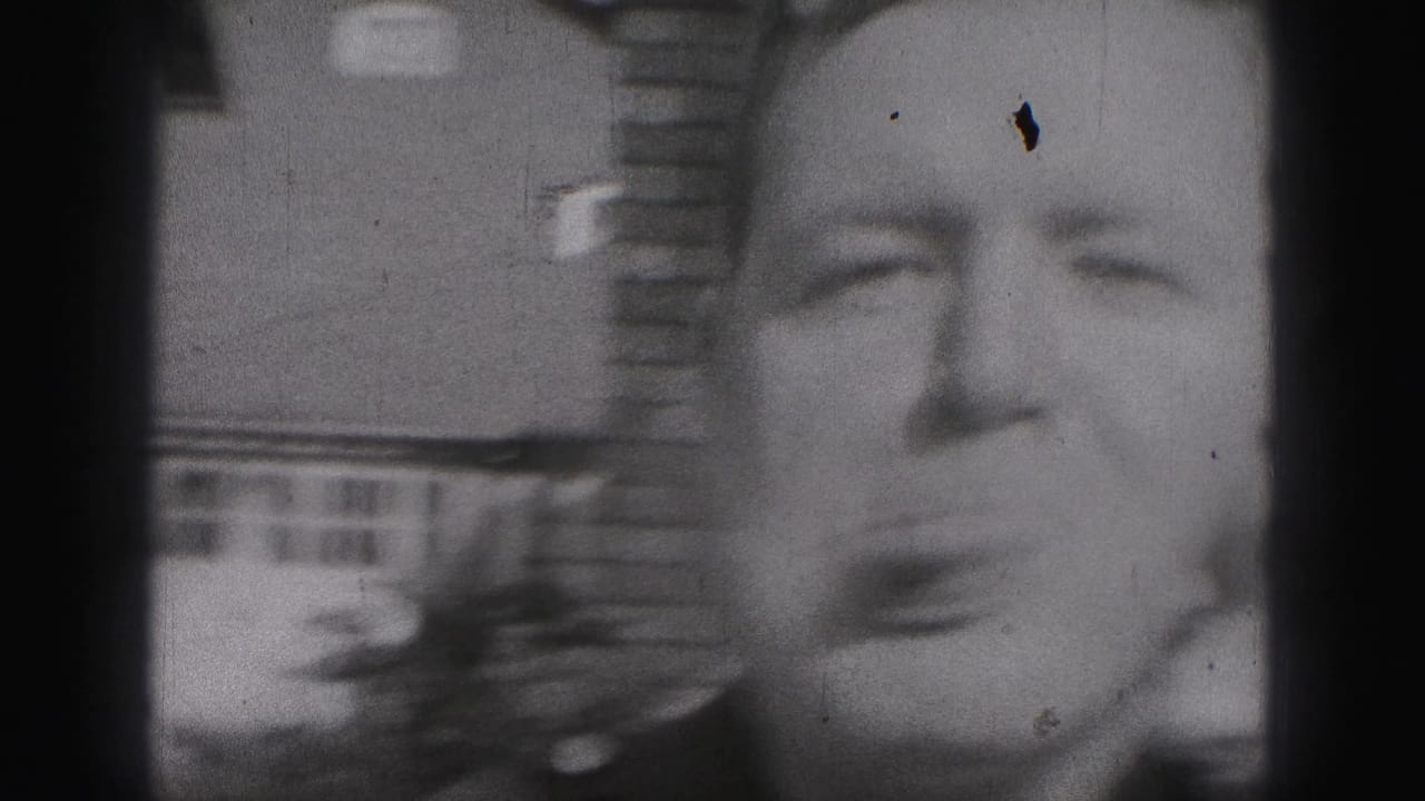 Close view of a man making a playful face beside a partially visible woman outdoors.