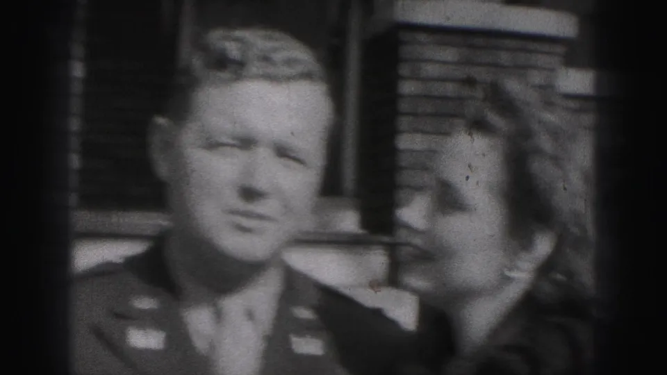 Black-and-white 1946 New Cumberland frame showing a uniformed man and woman joking closely as she raises her hand near him.